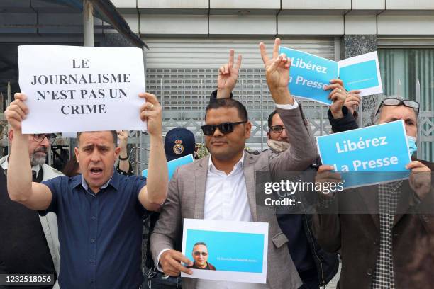 People attend a demonstration outside the headquarters of the French-language newspaper "Liberté" in a suburb of Algeria's capital Algiers on April...