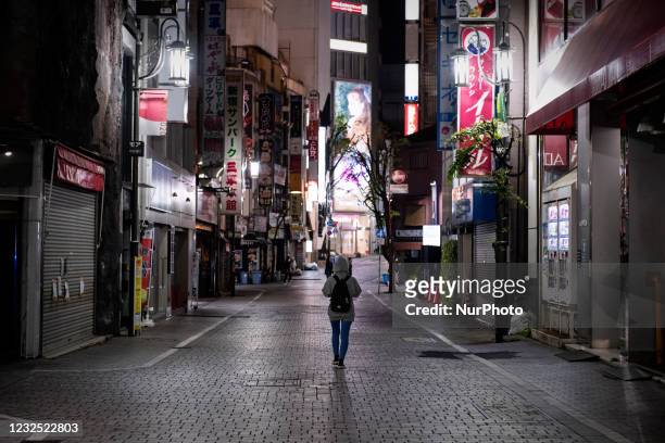 Young woman walks on the deserted street at downtown in Tokyo, Japan on April 25, 2021.