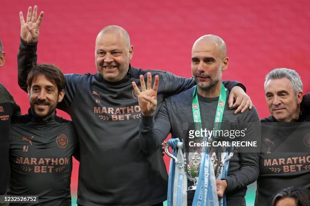 Manchester City's Spanish manager Pep Guardiola and his coaches pose with the trophy after the English League Cup final football match between...