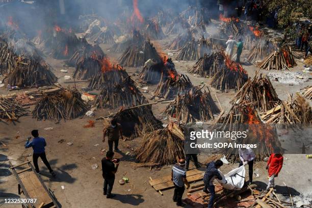Burning pyres of Covid-19 deceased people at a crematorium in New Delhi. India Health Ministry recorded a total of 17 millions infections 192,000...