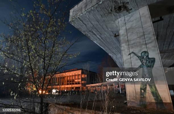 People gather on the central square of the ghost town of Pripyat near the Chernobyl Nuclear Power Plant early on April 26 to commemorate the 35th...