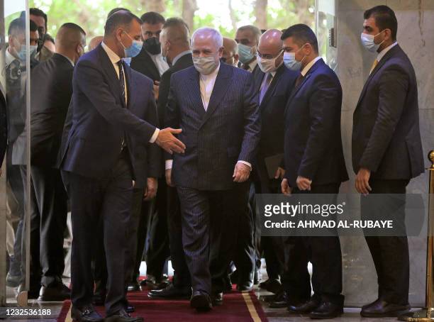 Iran's Foreign Minister Mohammad Javad Zarif is welcomed upon his arrival for his meeting with his Iraqi counterpart in Iraq's capital Baghdad on...