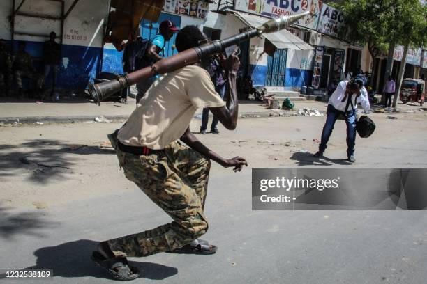Photographers take pictures of a Somali military force member supporting anti-government while he poses on a street in Mogadishu, Somalia, on April...