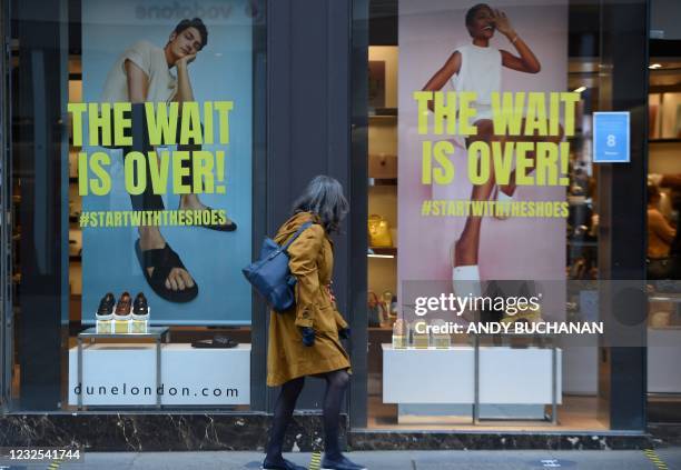 Pedestrian walks past a re-opened shoe shop in Glasgow on April 26, 2021 following the relaxing of some Covid-19 restrictions in Scotland, after the...