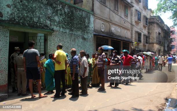 Indian voters queue to cast their votes at a polling station during the 7th phase of West Bengal's state legislative assembly elections in Kolkata,...