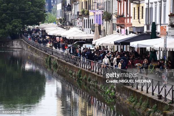 People having a drink bar terraces and walk down the Navigli in downtown Milan on April 26, 2021 as bars, restaurants, cinemas and concert halls...