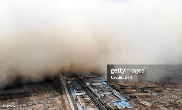 This aerial photo taken on April 25, 2021 shows a sandstorm engulfing a village in Linze county, in the city of Zhangye in China's northwestern Gansu...