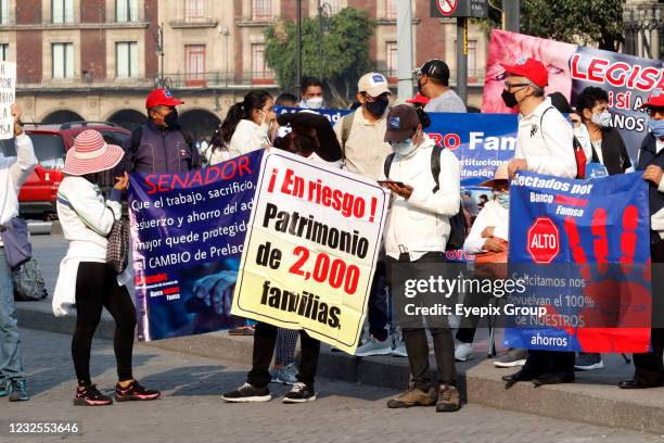 Persons take part during a protest, outside the National Palace, due were victims of fraud by the Banco Ahorro Famsa, demand returns their savings....