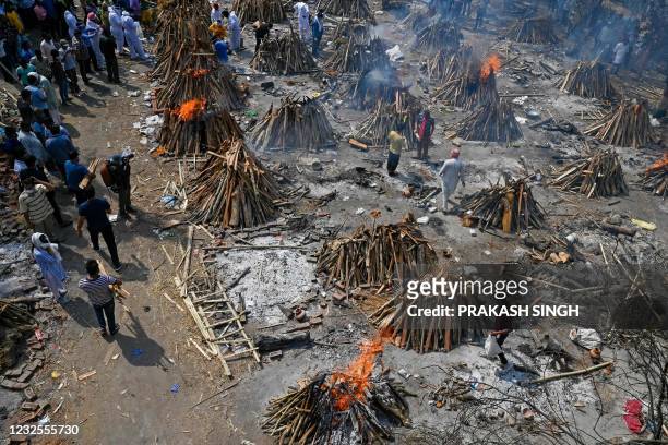 Burning funeral pyres can be seen of the patients who died of the Covid-19 coronavirus at a crematorium in New Delhi on April 27, 2021.