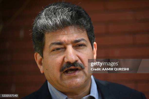 Pakistani prominent journalist Hamid Mir speaks with AFP during an interveiw in Islamabad on April 27, 2021. - Children play cricket in a patch of...