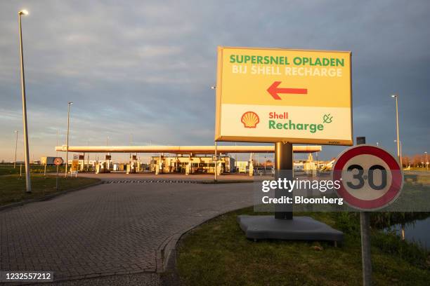 Direction sign for electric vehicle charging stations at a Royal Dutch Shell Plc gas station in Rotterdam, Netherlands, on Tuesday, April 27, 2021....