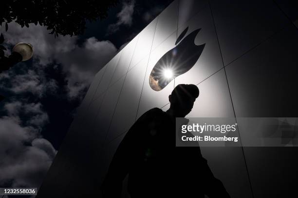 Pedestrian walks past an Apple store in San Francisco, California, U.S., on Monday, April 26, 2021. Apple Inc. Is increasing its U.S. Investments by...