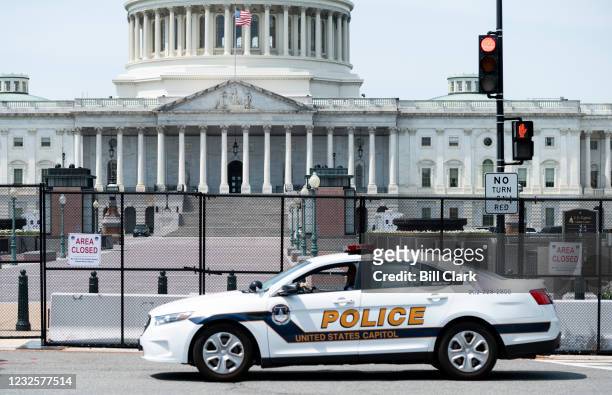 Capitol Police patrol car drives past the fence perimeter on the east side of the U.S. Capitol before President Joe Biden delivers his address to the...