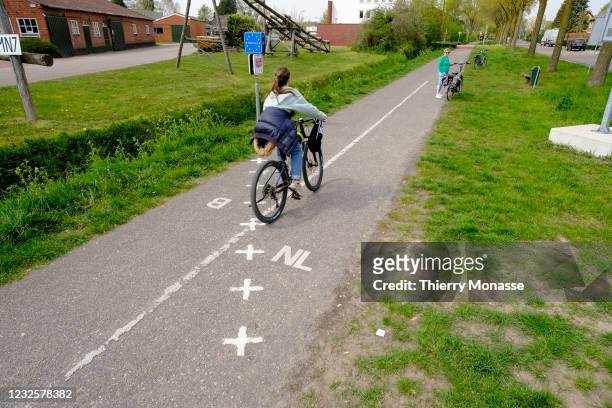 Cyclists cross the border from Belgium to Baarle-Nassau in the Netherlands on April 28, 2021 in the enclaved village of Baarle-Hertog Belgium....