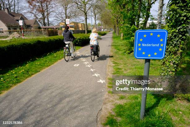 Cyclists cross the border from Belgium to Baarle-Nassau in the Netherlands on April 28, 2021 in the enclaved village of Baarle-Hertog Belgium....