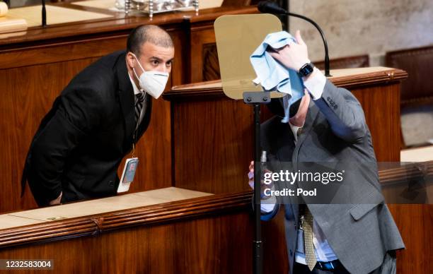 Staffers clean the teleprompter in preparation for U.S. President Joe Biden addressing a joint session of Congress in the House chamber of the U.S....