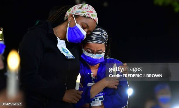 Registered nurses Theresa Austin and Rosell Mahawan grieve and console one another during a candlelight vigil at Kaiser Permanente Hospital in...