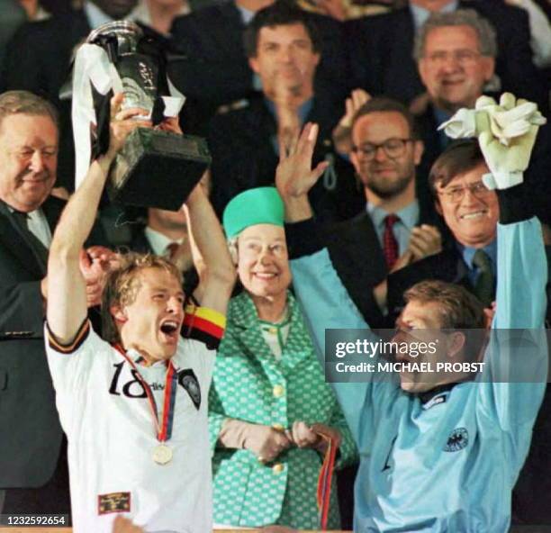 German team captain Jurgen Klinsmann raises the European Championship trophy presented to him by Britain's Queen Elizabeth II after his team beat the...