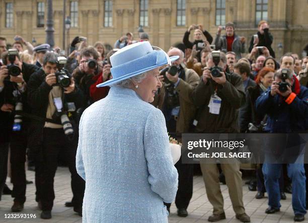 Press photographers snap pictures of Queen Elizabeth II outside the Louvre museum in Paris, where she viewed paintings which will form part of the...