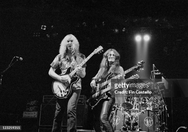 Alex Lifeson, Canadian guitarist, playing a guitar, and Geddy Lee, Canadian bassist and guitarist, playing a double-necked guitar, on stage during a...