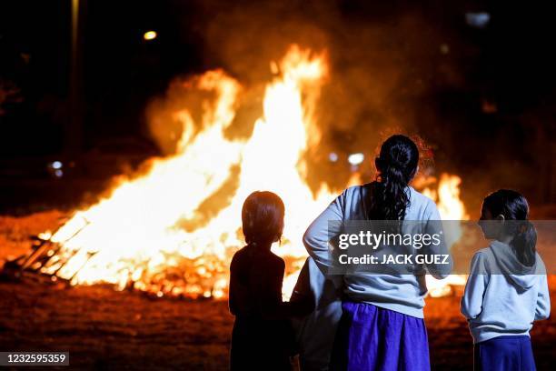 Israelis gather around a bonfire as they celebrate the Jewish holiday of Lag Baomer, marking the anniversary of the death of Talmudic sage Rabbi...