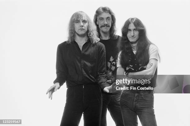Rush , Canadian rock band Rush, pose for a group studio portrait, against a white background, United Kingdom, in May 1979.