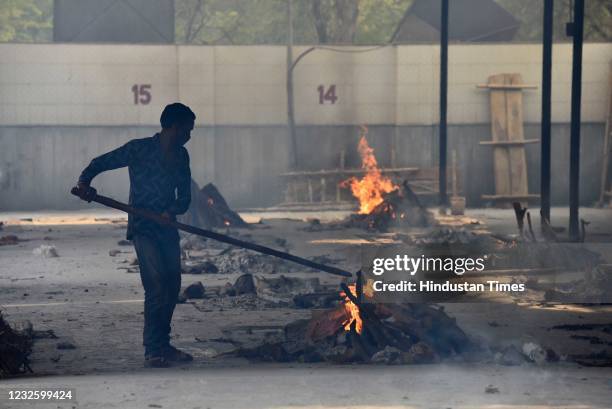 Man stoking a funeral pyre at the Subhash Nagar Crematorium, on April 29, 2021 in New Delhi, India.