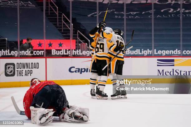 Jake Guentzel of the Pittsburgh Penguins celebrates with his teammates after scoring the game winning goal against the Washington Capitals in...