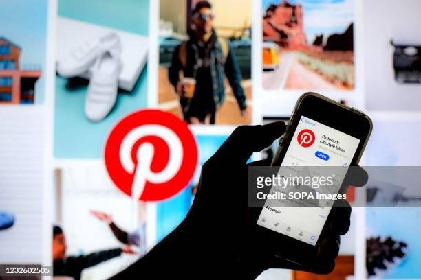 In this photo illustration a Pinterest app in App Store seen displayed on a smartphone screen with a Pinterest logo in the background.