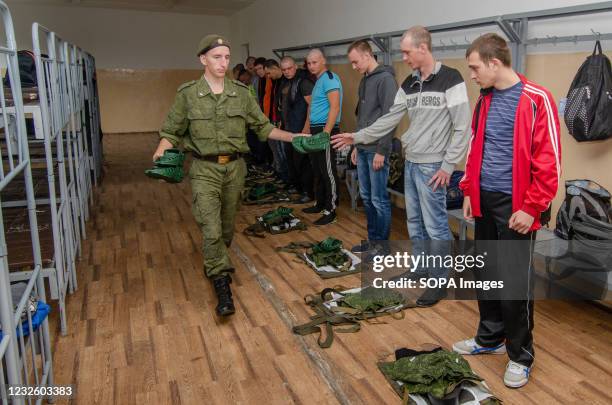 Soldier of the Russian army distributes personal belongings to recruits at a recruiting station in the city of Tambov before being sent to serve in...