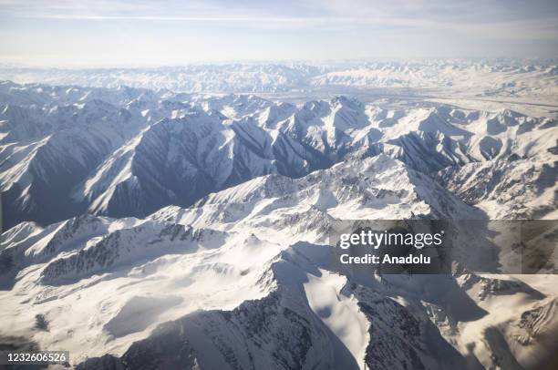 An aerial view taken from a commercial plane shows Tian Shan Range in Kyrgyzstan on April 29, 2021. The terrain of Kyrgyzstan, sometimes called the...