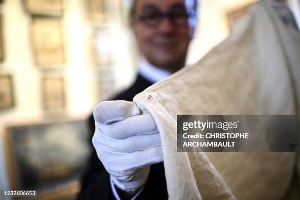 Auctioneer Jean-Pierre Osenat holds a shirt that belonged to French Emperor Napoleon I and marked with the initial 'N' and a 'crown' ahead of its...