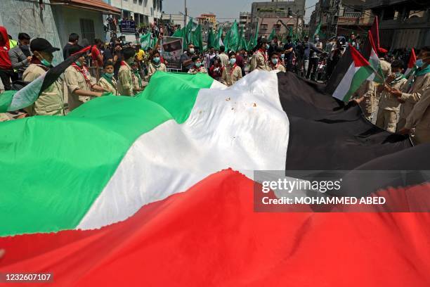 Palestinian protesters wave national and Hamas movement flags during a demonstration in the Jabalia refugee camp in the Gaza Strip on April 30...