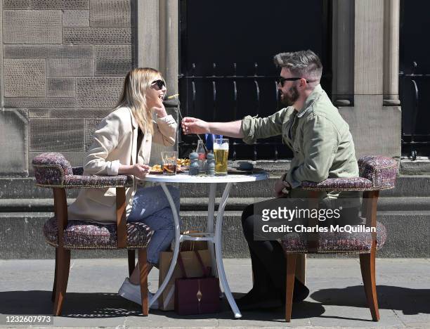 Couple are seen enjoying their lunch as pubs with outdoor facilities reopen on April 30, 2021 in Belfast, Northern Ireland. Non essential retail...