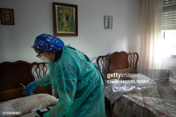 Spanish nurse Visitacion Mena prepares a dose of the Janssen vaccine to vaccinate 91-year-old Saturnina Puga against COVID-19 at her home in...