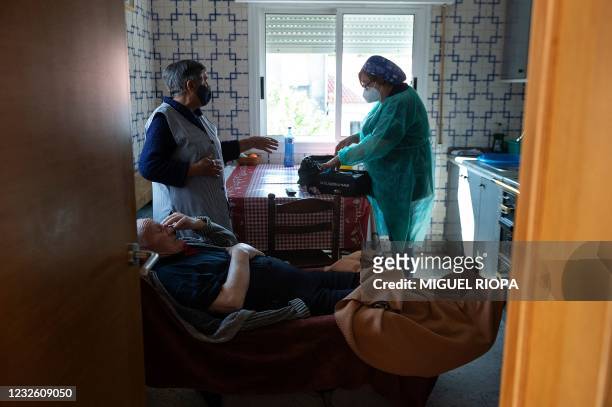 Spanish nurse Visitacion Mena prepares a dose of the Janssen vaccine to vaccinate Ramon Quintana against COVID-19 at his home in Taboadela during an...
