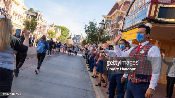In this handout photo provided by Disneyland Resort, Guests as are waved to by workers as they take in the sights and sounds of Main Street U.S.A. At...