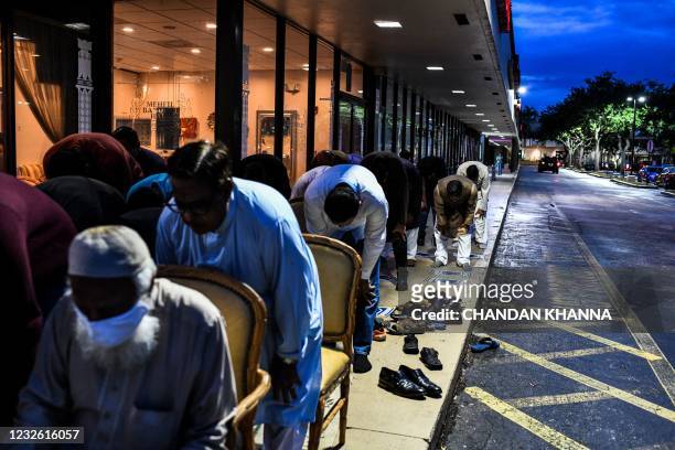 Muslim men offer prayers on the pavement outside a restaurant during the Muslim holy month of Ramadan in Lauderhill, on April 30, 2021. - Muslims...