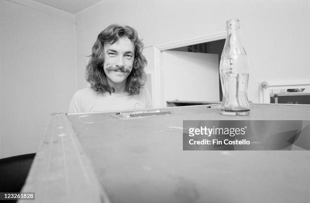 Neil Peart, drummer with Canadian rock band Rush, poses behind a luggage trunk backstage at the Gaumont in Southampton, Hampshire, England, United...