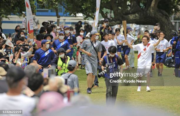 Former boxing champion Yoko Gushiken runs during the Tokyo Olympic torch relay in Ishigaki, Okinawa Prefecture, on May 1, 2021.