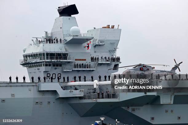 Crew stand to attentions as HMS Queen Elizabeth aircraft carrier leaves Portsmouth Naval Base on the south coast of England, on May 1 to take part in...