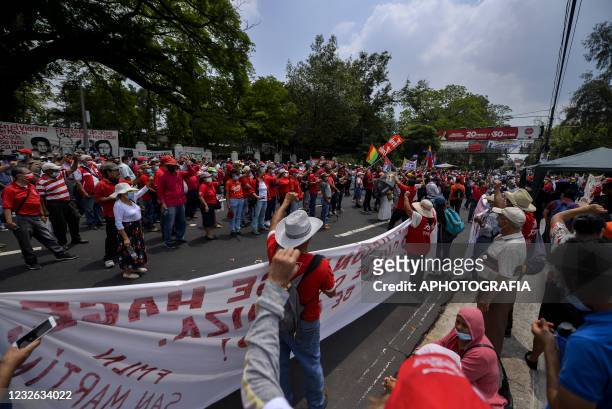 Demonstrators march holding banners as part of International Workers' Day on May 1, 2021 in San Salvador, El Salvador. Unions of both public and...