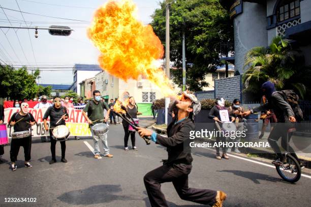 Demonstrator spits fire while marching as part of International Workers' Day on May 1, 2021 in San Salvador, El Salvador. Unions of both public and...
