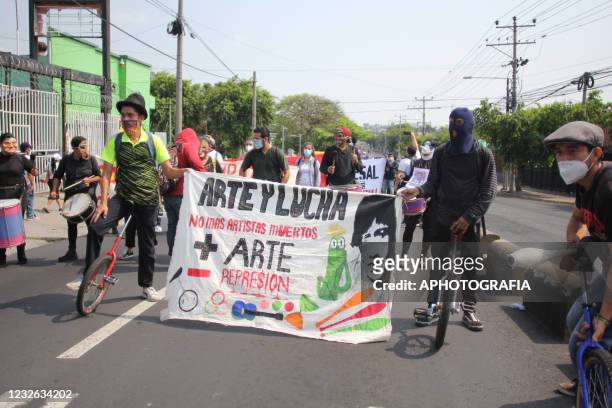 Demonstrators march holding banners as part of International Workers' Day on May 1, 2021 in San Salvador, El Salvador. Unions of both public and...