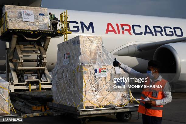Ground staff unload the Covid-19 coronavirus medical supplies from France, upon the arrival of a cargo plane at the Indira Gandhi International...