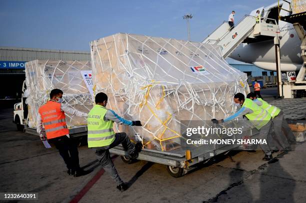 Ground staff unload the Covid-19 coronavirus medical supplies from France, upon the arrival of a cargo plane at the Indira Gandhi International...