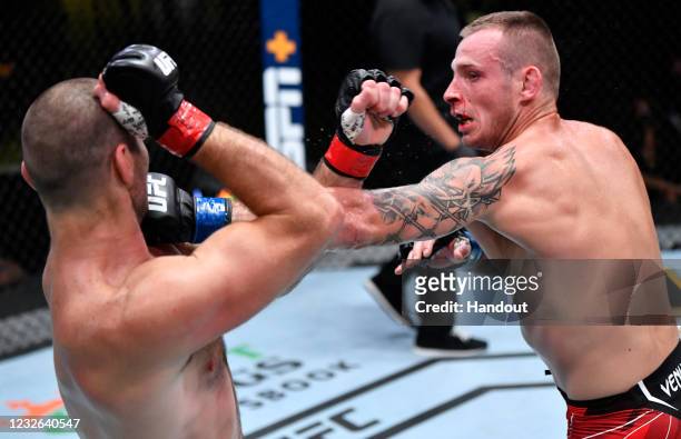 In this UFC handout, Krzysztof Jotko of Poland punches Sean Strickland in a middleweight bout during the UFC Fight Night event at UFC APEX on May 01,...