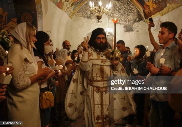 Greek Orthodox priest swings a censer as he celebrates the Easter night mass at the ancient monastery of Our Lady of Hamatoura, built in the rocky...