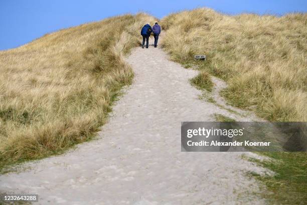 Tourists walk by famous ´Ellenbogen´ beach during the third wave of the coronavirus pandemic on May 2, 2021 on Sylt Island, Germany. Sylt, Germany's...