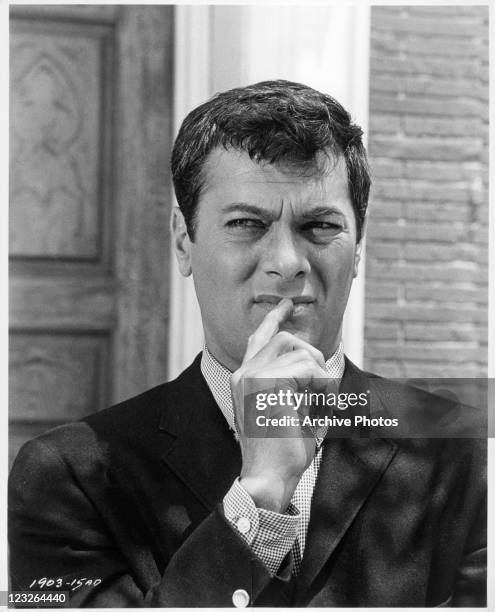 Tony Curtis with his finger to his lips in a scene from the film 'The Great Imposter', 1961.